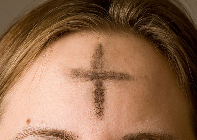 Ash cross on woman's forehead